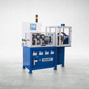 A blue LKA 14 AM - Automatic Annealing Machine for precise and fast cutting of wire rope. It has a clear protective cover labeled "Talurit®" and is positioned on a clean, grey floor. This annealing machine features control buttons, knobs, and visible gears. A tower light is mounted on top, indicating operational status. © Copyright Talurit AB. All rights reserved.