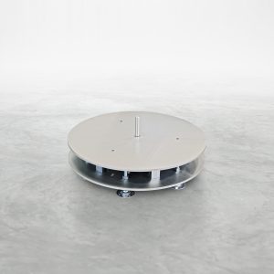 Talurit® An AVL 5000B - Uncoiling Machine, featuring a round, flat metallic base with a central vertical rod and four wheels underneath, reminiscent of Talurit Group's swagers. The device rests on a smooth, gray surface against a plain white background in a minimalistic setting. © Copyright Talurit AB. All rights reserved.