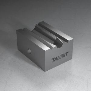 Talurit® A metal block with "TALURIT" etched on one side, known as the KH - Conical Swaging Dies with Tap, is commonly used in the mechanical splicing of wire rope. It features a grooved, cylindrical cut on the top surface and a hole through one side. Its smooth and reflective surface sharply contrasts with the cracked concrete floor beneath it. © Copyright Talurit AB. All rights reserved.