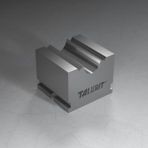 Talurit® A rectangular metal piece with a grooved, semi-cylindrical indentation is placed on a surface. The word "TALURIT" is printed on the side of this R - Cylindrical Swaging Die. The surface it rests on shows faint cracks. © Copyright Talurit AB. All rights reserved.
