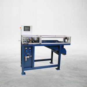 The Talurit® LKA 04 - Automatic Cutting Machine, featuring a blue industrial design with a control panel, transparent cover, and various components, is situated on a smooth gray concrete floor. It is equipped with multiple buttons, dials, and a small digital display designed for automated cutting of wire rope. © Copyright Talurit AB. All rights reserved.