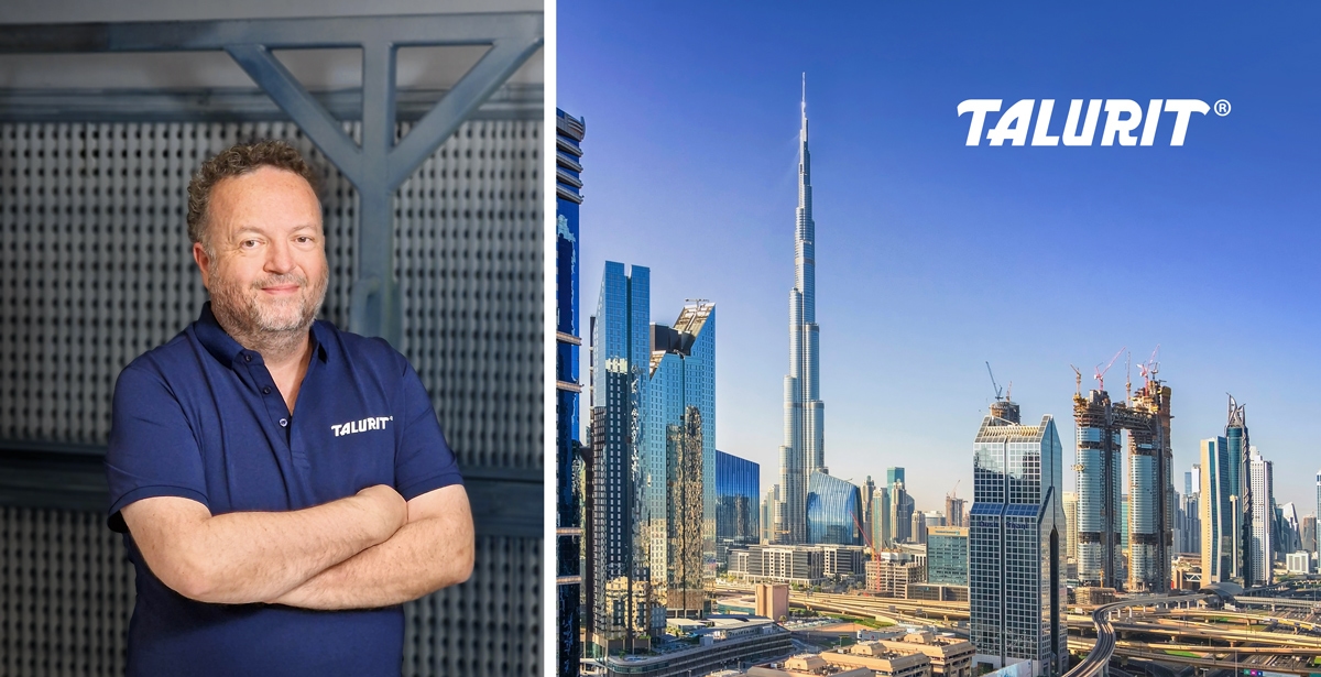Steve-Hodgkins_(Talurit-Middle-East)-1200px Talurit® Steve Hodgkins wearing a navy blue TALURIT polo shirt stands with arms crossed beside a cityscape featuring skyscrapers and the Burj Khalifa, highlighting Talurit Middle East, with the TALURIT logo above the buildings. © Copyright Talurit AB. All rights reserved.