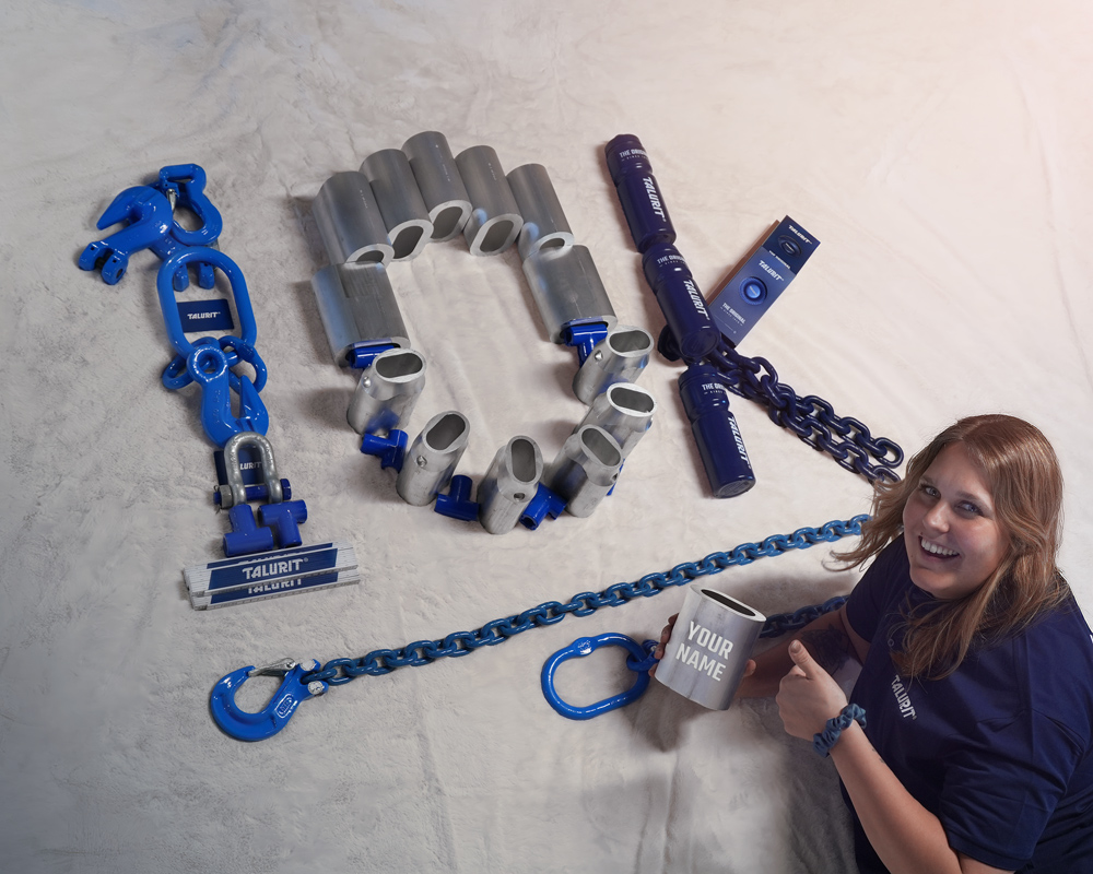 Talurit® A woman holding a aluminium ferrule sits next to metal hardware pieces arranged to spell “10K” on a light surface. Some pieces are blue and branded, and a blue chain extends toward her. © Copyright Talurit AB. All rights reserved.