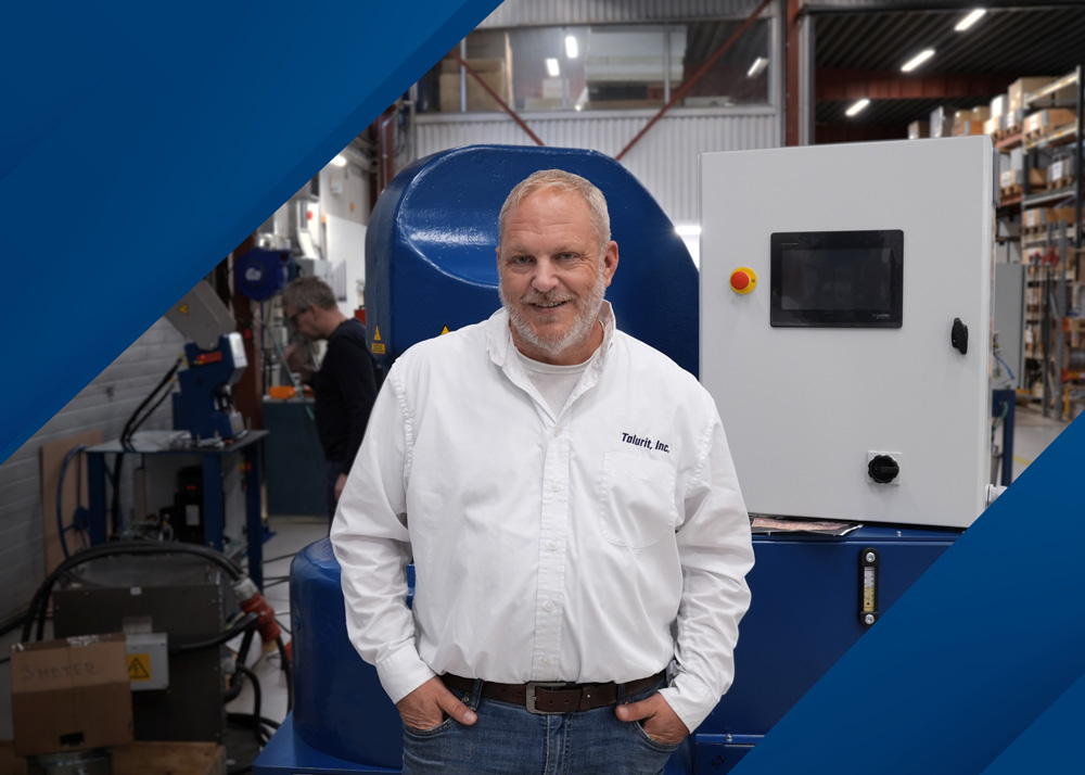Jason-Ruby-Press-release-Oct-2026-Webb-1000px Talurit® Jason Ruby, Vice President of Operations, stands in a white button-down shirt in front of industrial machinery in a warehouse. © Copyright Talurit AB. All rights reserved.