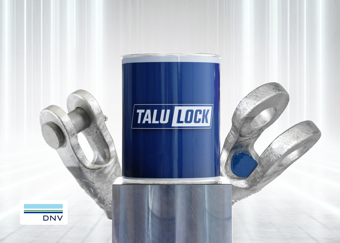 TALULOCK®-Product-photo-5×7-Website-1100px Talurit® A blue TaluLock® canister centered on a metal pedestal, flanked by two steel socketing sockets, with a DNV logo in the corner. Wire rope socketing resing solution. © Copyright Talurit AB. All rights reserved.